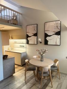 a kitchen and dining room with a table and chairs at OrkanaApart in Nowy Targ