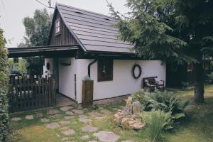 a small white house with a black roof at Pod Buchtou in Daňkovice