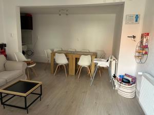 a living room with a table and white chairs at Pensiunea Melinda in Praid
