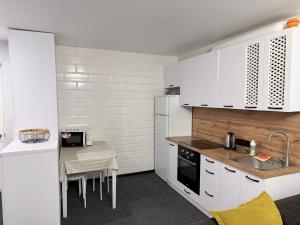 a kitchen with white appliances and a small table at Готель на Шнеєрсона in Dnipro +25 photos