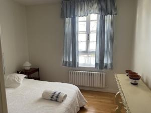 a white bedroom with a bed and a window at Casa Sierrapando - by Wehomes in Torrelavega