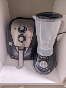 a black blender sitting on top of a shelf at Pontal Flat 103 in Coruripe