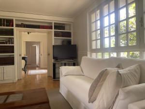 a living room with a white couch and a tv at Casa Sierrapando - by Wehomes in Torrelavega