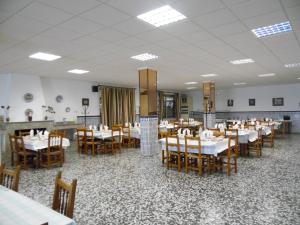 uma sala de jantar com mesas e cadeiras num restaurante em Hostal Arias em Zafra