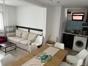 a living room with a couch and a table and chairs at Pensiunea Melinda in Praid