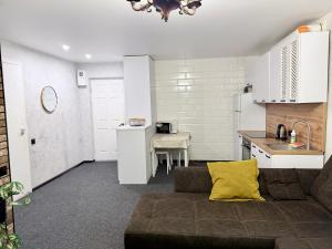 a living room with a couch and a kitchen at Готель на Шнеєрсона in Dnipro