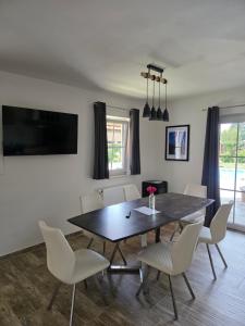 a dining room with a black table and white chairs at Ferienwohnungen Forever in Gamlitz