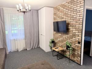 a living room with a tv on a brick wall at Готель на Шнеєрсона in Dnipro