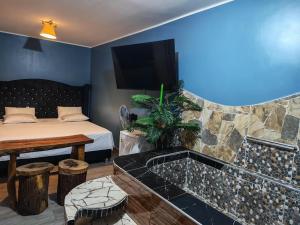 a room with a tub with a bed and a tv at Hotel Las Lomas de Pisco in Pisco