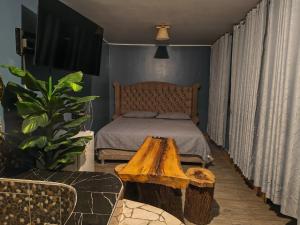 a bedroom with a bed and a wooden table at Hotel Las Lomas de Pisco in Pisco