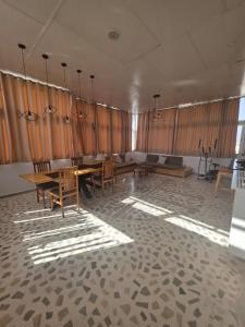 a room with a table and chairs and curtains at Résidence Mila in Sukrah