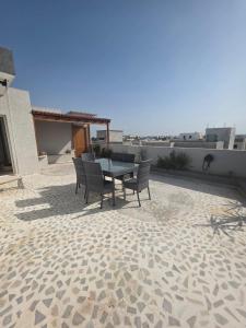 a patio with a table and chairs on a roof at Résidence Mila in Sukrah