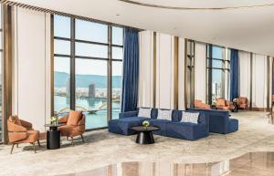 a living room with a blue couch and chairs at TUI BLUE Han River in Danang
