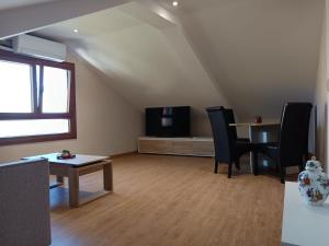 a living room with a tv and a table and chairs at Casa Pampillon in Cangas de Morrazo