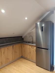 a kitchen with a stainless steel refrigerator and wooden cabinets at Casa Pampillon in Cangas de Morrazo