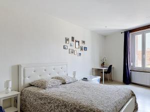 a white bedroom with a bed and a window at EM LIFE COLMAR in Colmar