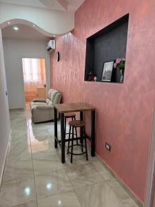 a living room with a table and a pink wall at Maison D'orleans By Catalano in Palermo