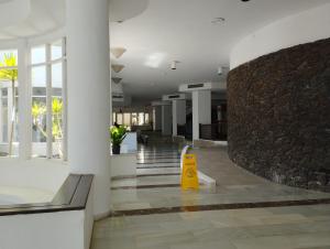 a lobby with a yellow sign in the middle of a building at Ocean View Deluxe Studio with Sunset Balcony and Pool Playa Paraiso in Playa Paraiso +24 photos