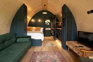 a bedroom with a bed and a couch and a tv at Bainton Burrows by Wigwam Holidays in Great Driffield