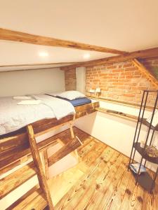 a room with two bunk beds and a brick wall at Apartmán Lotta in Kežmarok