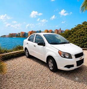 a white car parked next to a body of water at The Almas Apartment in Willemstad