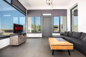 a living room with a couch and a tv at Summer & Sun in Vathí