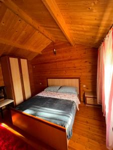 a bedroom with a bed in a wooden cabin at Llogara Wood Lodge in Vlorë