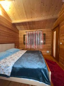 a bedroom with a bed in a wooden cabin at Llogara Wood Lodge in Vlorë