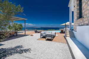 a patio with some chairs and a swimming pool at Summer & Sun in Vathí