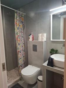 a bathroom with a toilet and a sink and a shower at Cosy Stay in Platamonas