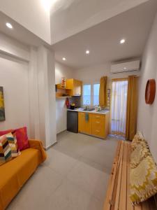 a living room with a couch and a kitchen at Cosy Stay in Platamonas