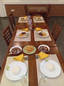 a long wooden table with plates of food on it at Leon Hilltop Resort in Kitulgala