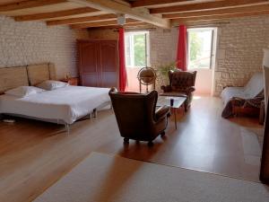 a bedroom with a bed and a couch and chairs at Têtes à l'air in Montils +78 photos