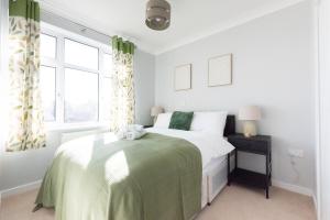 a bedroom with a bed with a green blanket at 4BR Braintree Contractor - long stay in Braintree