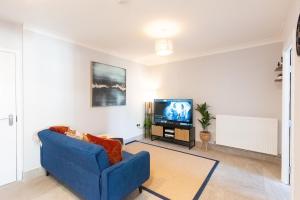 a living room with a blue couch and a tv at 4BR Braintree Contractor - long stay in Braintree