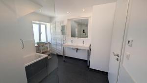 a bathroom with a sink and a tub and a mirror at Ferienwohnung Malbrich in Gräfenberg