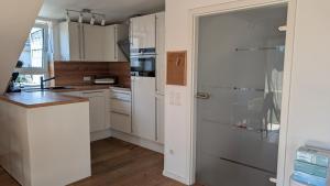 a kitchen with white cabinets and a refrigerator at Ferienwohnung Malbrich in Gräfenberg +20 photos