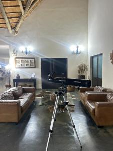a living room with a piano and couches at Lodge Kapembawé in Benguela
