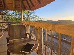 a chair on a porch with a view of the ocean at Lodge Kapembawé in Benguela +2 photos