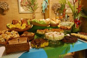 a table topped with lots of different types of food at Itamambuca Eco Resort in Ubatuba
