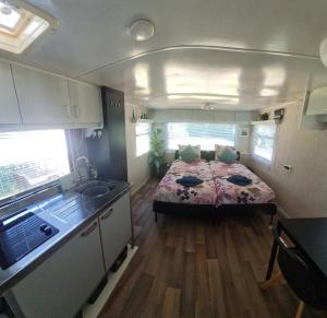 a small bedroom with a bed in a trailer at de Tweelingen - de Tien Heugten in Schoonloo +3 photos