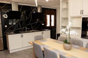 a kitchen with white cabinets and a table with chairs at Viceda Home in Yecla