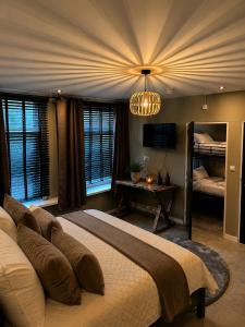 a bedroom with a large bed and a chandelier at Boutique Hotel Mare in Middelburg +11 photos