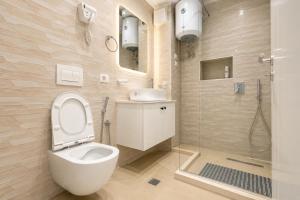 a bathroom with a toilet and a sink and a shower at Oryn Suites in Tirana +32 photos