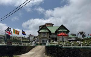 a house on a dirt road with flags in front of it at Gregory's Bungalow in Nuwara Eliya +44 photos