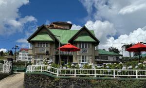 a house with red umbrellas in front of it at Gregory's Bungalow in Nuwara Eliya