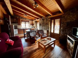 a living room with a couch and a table at El Rincón de la Rosa in Brugos de Fenar +25 photos