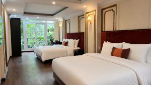 a hotel room with two beds and a window at The 39 Lane Hotel Hanoi in Hanoi