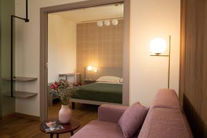 a living room with a couch and a bedroom at Salvia Hotel in Poggio Moiano