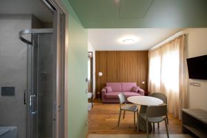 a living room with a pink couch and a table at Salvia Hotel in Poggio Moiano